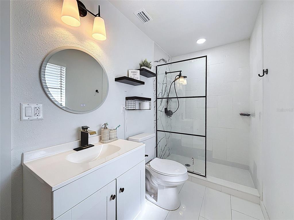 1652 Larkin Road Spring Hill, FL 34608 - Photo 14 of 29 a bathroom with a toilet sink and a mirror