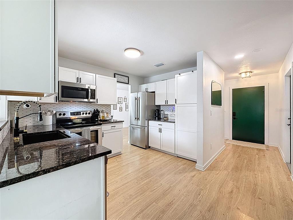 1652 Larkin Road Spring Hill, FL 34608 - Photo 4 of 29 a kitchen with granite countertop a refrigerator a stove top oven a sink and dishwasher