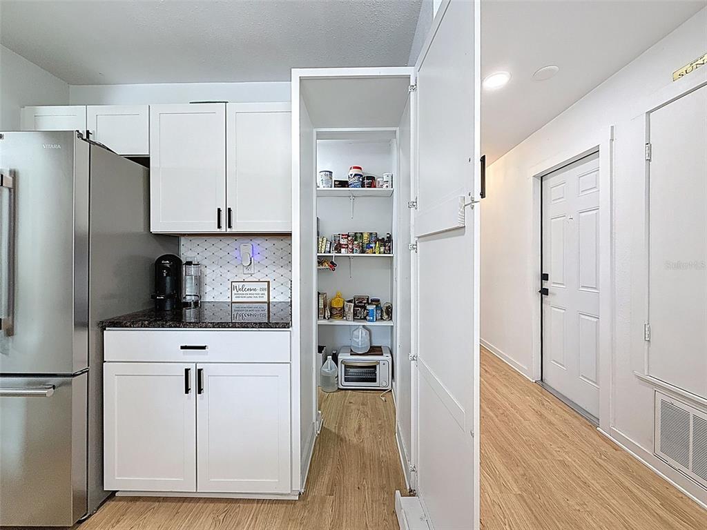 1652 Larkin Road Spring Hill, FL 34608 - Photo 5 of 29 a kitchen with white cabinets and refrigerator
