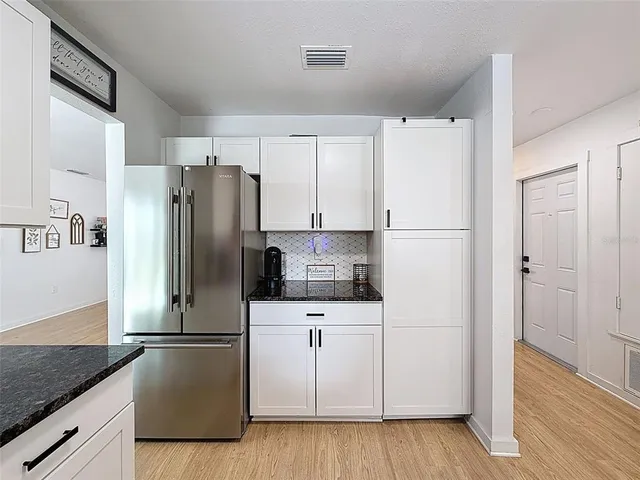 a kitchen with stainless steel appliances a refrigerator sink and cabinets