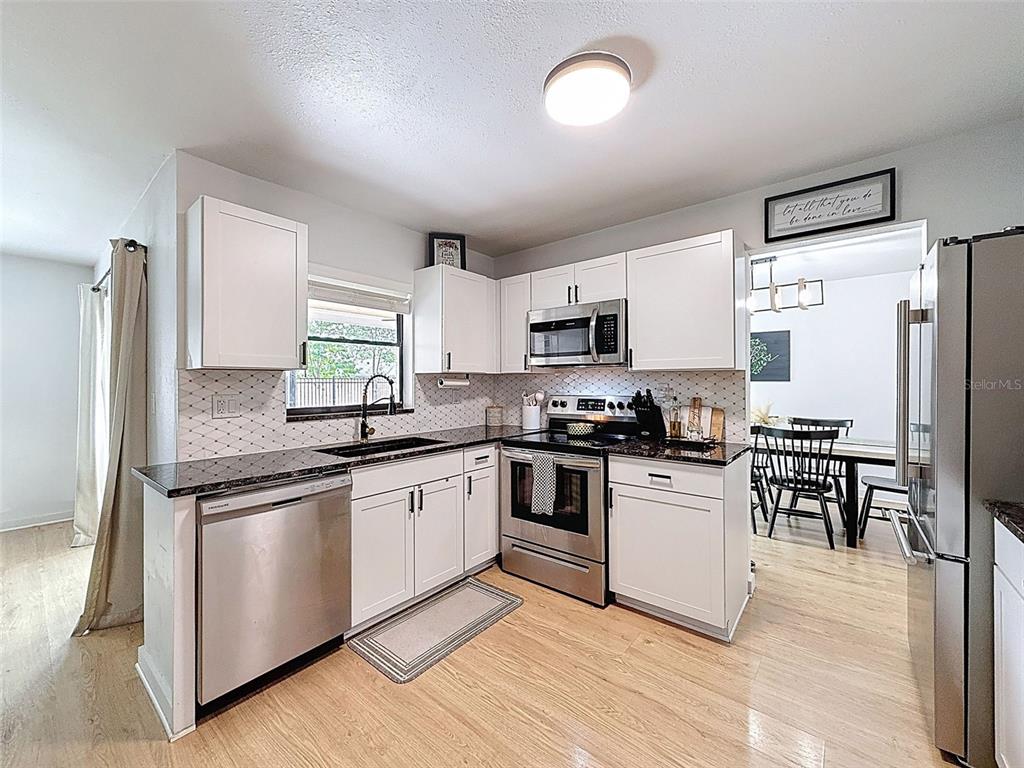 1652 Larkin Road Spring Hill, FL 34608 - Photo 7 of 29 a kitchen with granite countertop appliances cabinets and a counter space