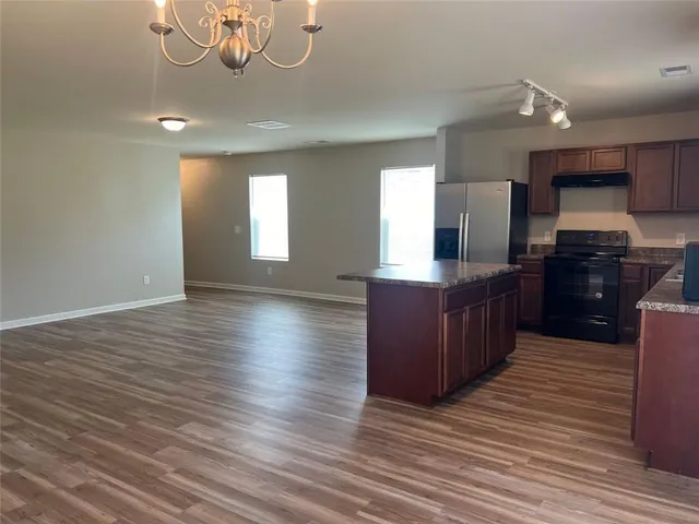 a kitchen with stainless steel appliances granite countertop a sink counter space and wooden floor