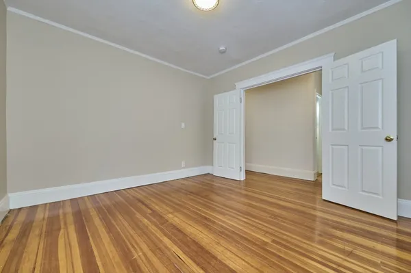 a view of an empty room with wooden floor