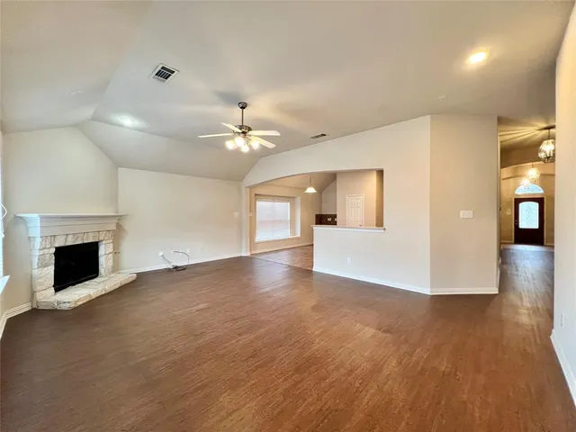 a view of a livingroom with a fireplace a chandelier and windows