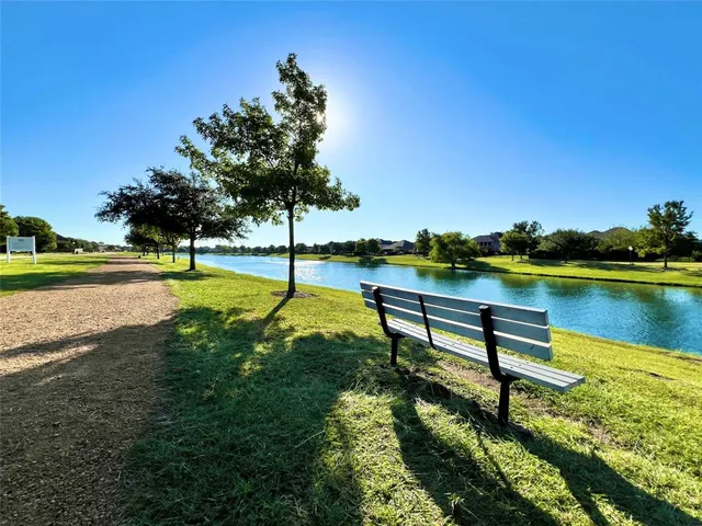 a view of a lake with couches and wooden fence
