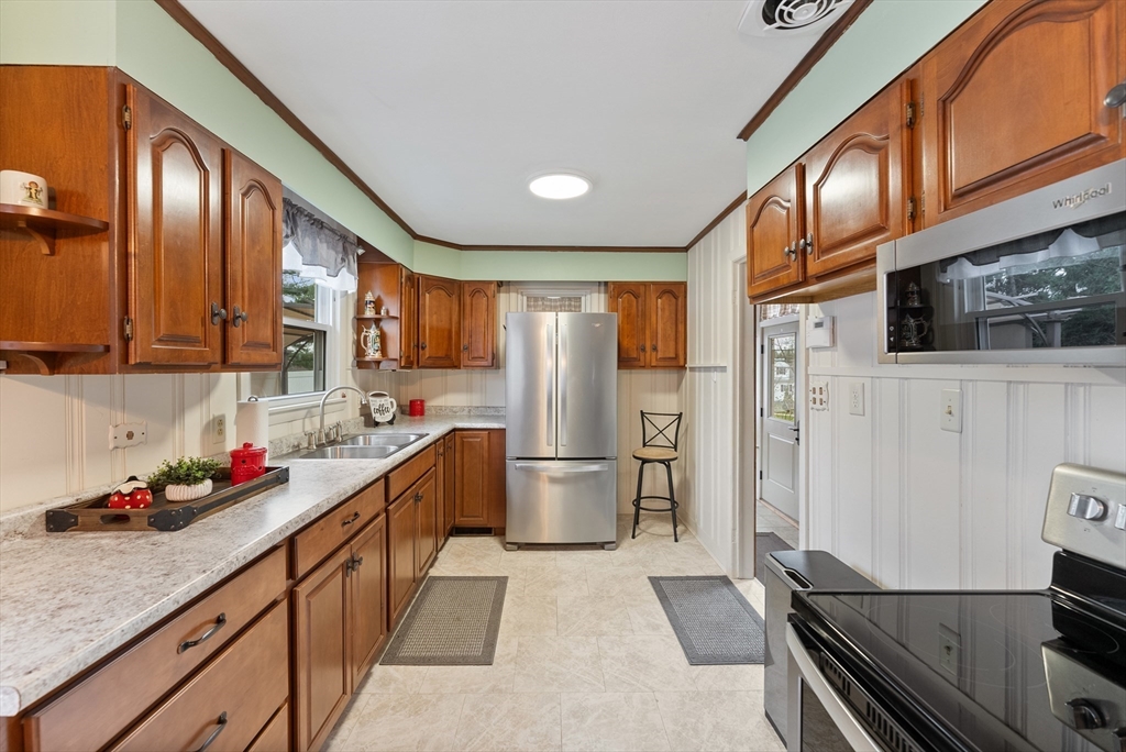 430 Amostown Road West Springfield, MA 01089 - Photo 13 of 41 a kitchen with stainless steel appliances granite countertop a refrigerator a stove and a sink with wooden cabinets