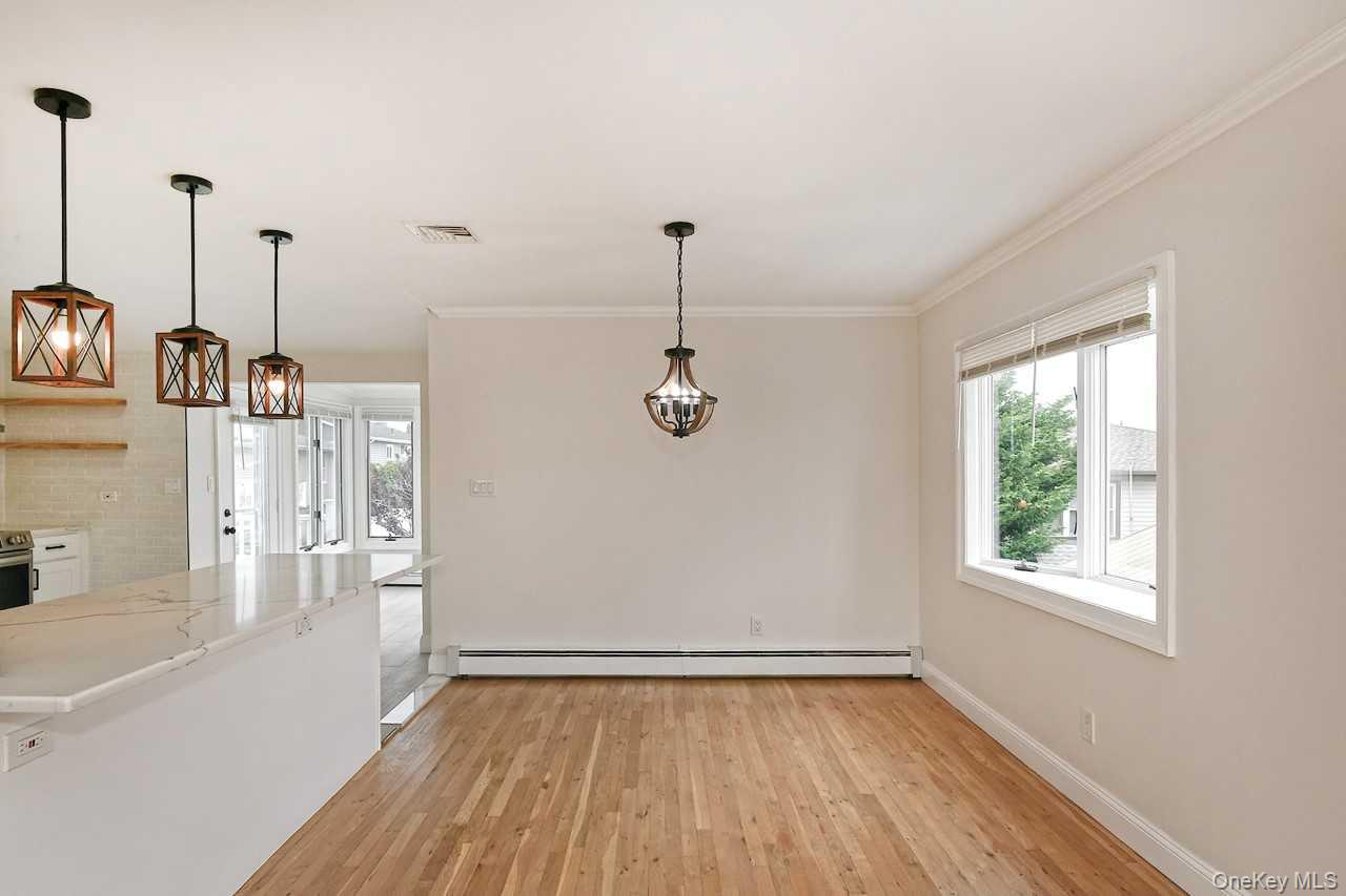 107 Beverly Road Massapequa, NY 11758 - Photo 10 of 41 a view of a room with wooden floor and windows