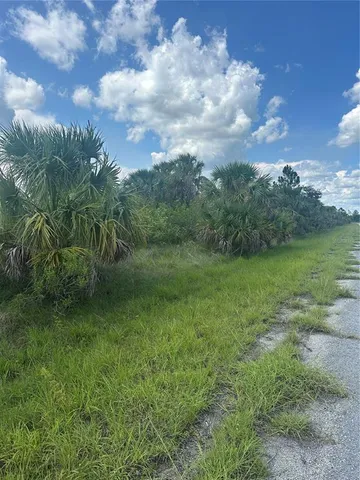 a view of a green field with wooden fence