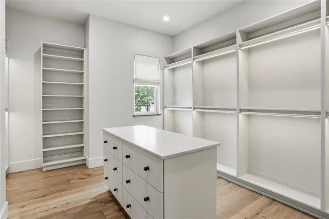 a view of a kitchen with white cabinets and a window