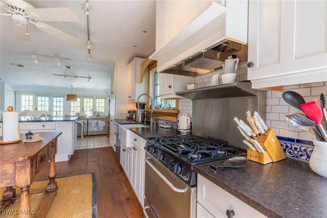 a kitchen with a dining table chairs and large window