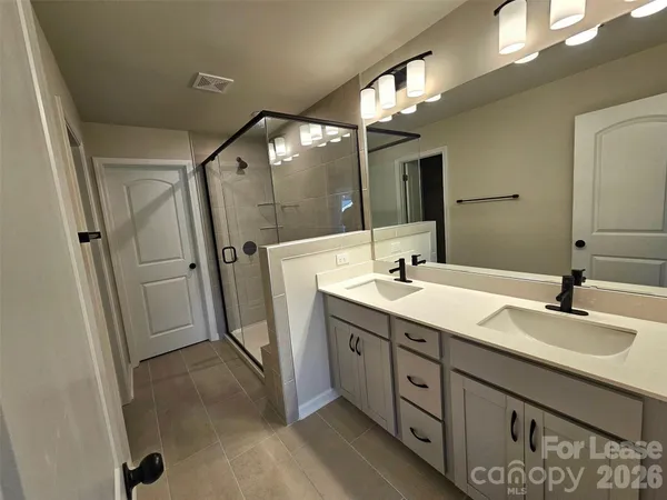 a spacious bathroom with double sink and mirror
