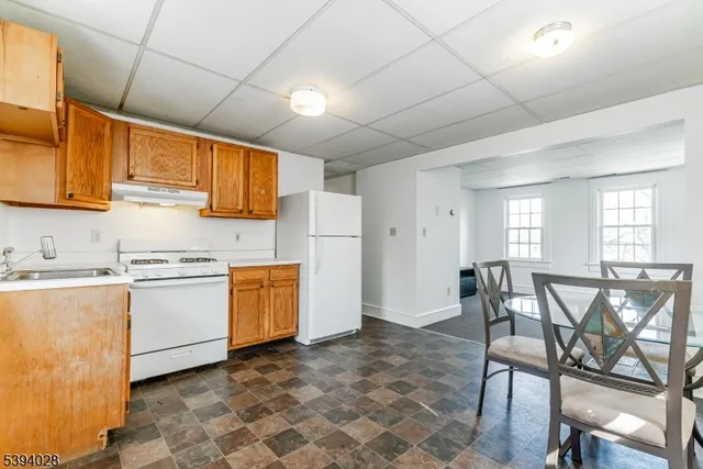 a kitchen with a stove a refrigerator and furniture