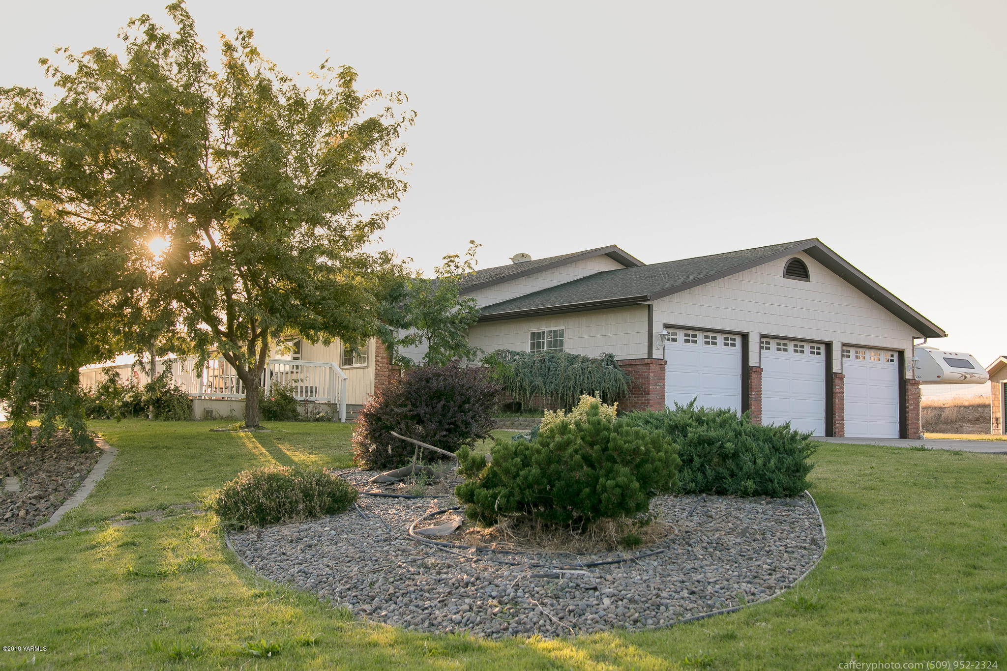 11517 Mieras Road Yakima, WA 98901 - Photo 20 of 57 a view of a house with a small yard plants and a large tree