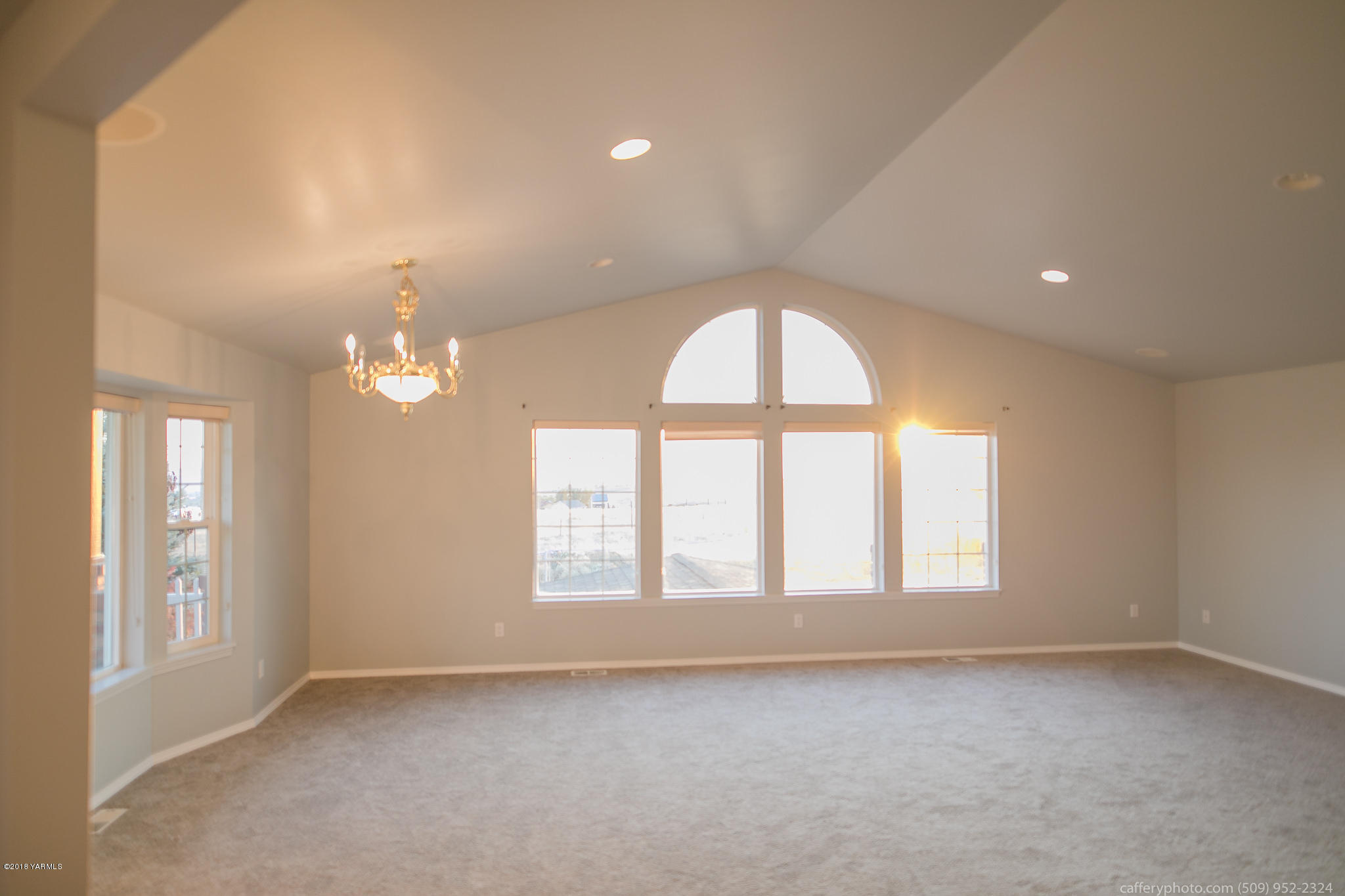 11517 Mieras Road Yakima, WA 98901 - Photo 49 of 57 an empty room with windows and chandelier
