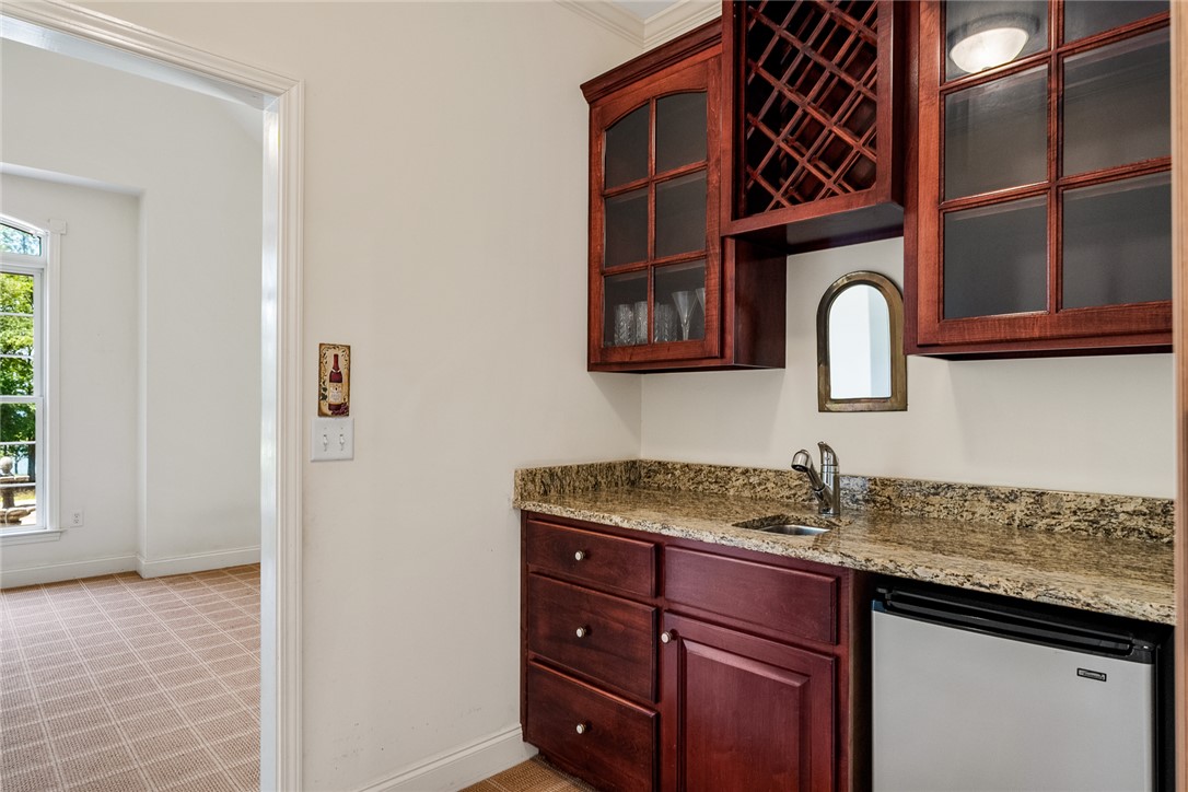 135 Sunset Bay Boulevard Seneca, SC 29672 - Photo 22 of 50 A well-appointed wet bar offers elegant wood cabinetry and a compact refrigerator for entertaining ease.