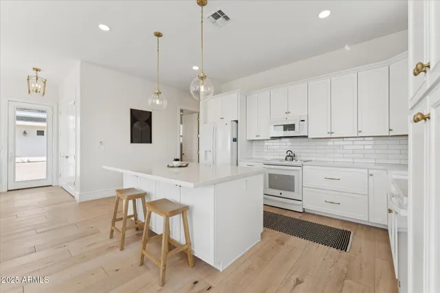 a kitchen with stainless steel appliances white cabinets and a refrigerator