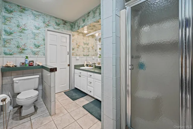 a bathroom with a granite countertop sink mirror and toilet