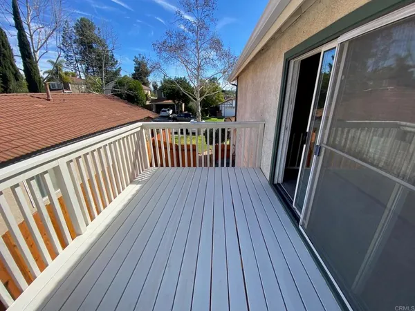 a view of backyard with a deck and wooden floor