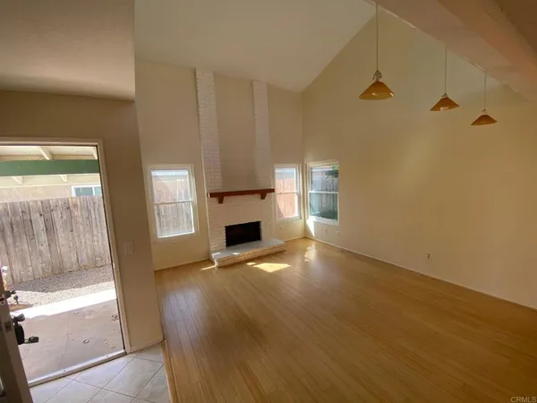 a view of empty room with wooden floor and fireplace