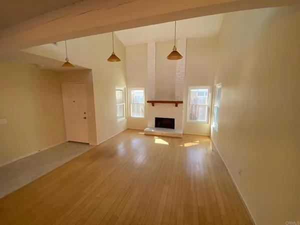 a view of empty room with a fireplace and wooden floor