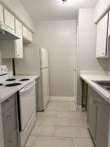a kitchen with a sink cabinets and a refrigerator