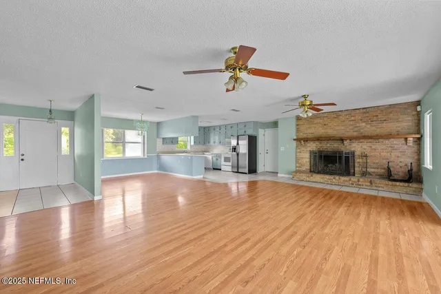 a view of a livingroom with wooden floor and a ceiling fan
