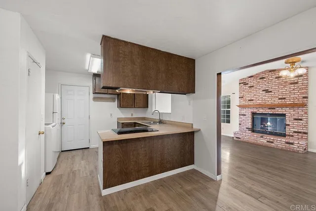 a kitchen with stainless steel appliances a stove top oven a sink and a fireplace