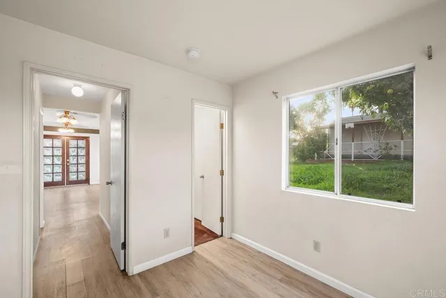 an empty room with wooden floor and a window