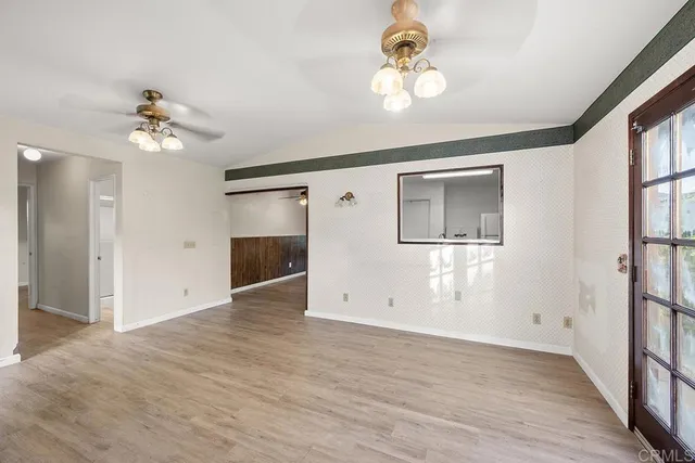 a view of an empty room with a chandelier fan