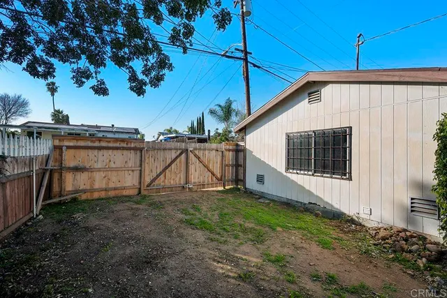 a view of a house with backyard and wooden fence