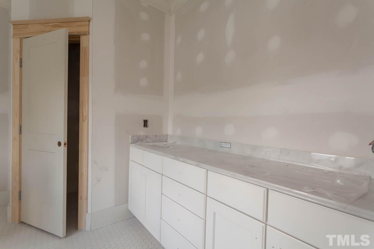 309 Georgetown Road Raleigh, NC 27608 - Photo 14 of 19 a bathroom with a granite countertop sink and white cabinets