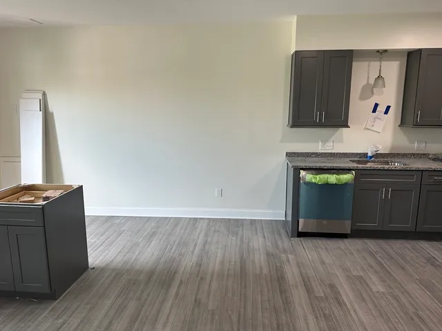 a view of a kitchen with wooden floor and a sink
