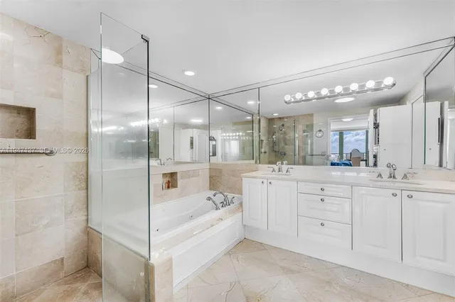 a bathroom with a tub a sink shower and mirror