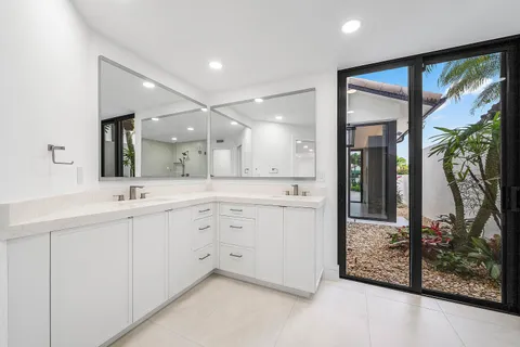 an empty room with an entryway and chandelier fan