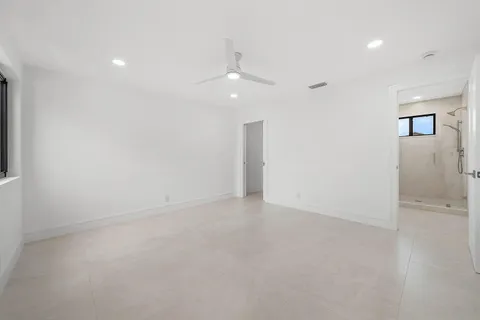 an empty room with a window and ceiling fan