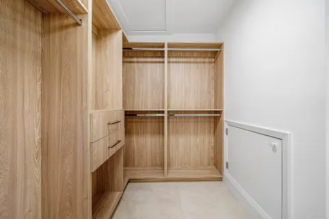 a view of a white house with a swimming pool and a lawn chairs under an umbrella