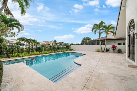 a view of a white house with a big yard and potted plants