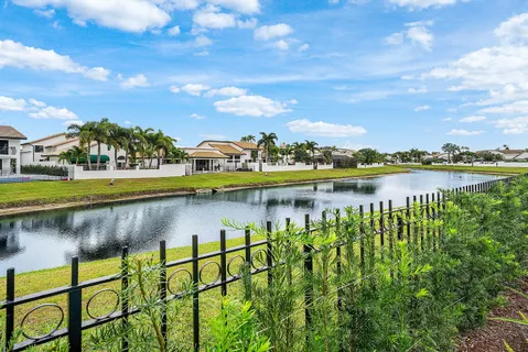 a view of a white house with a yard and potted plants