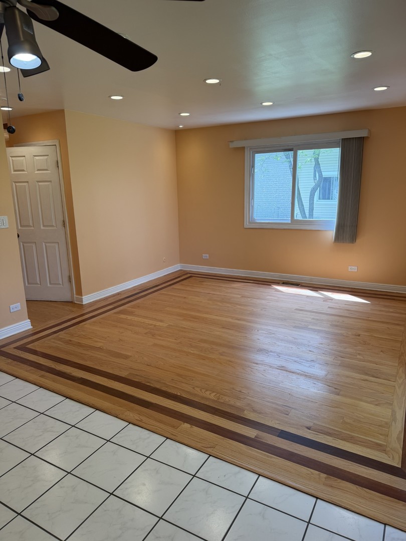 606 Bridgeport Place Wheeling, IL 60090 - Photo 11 of 25 a view of an empty room with wooden floor and a window