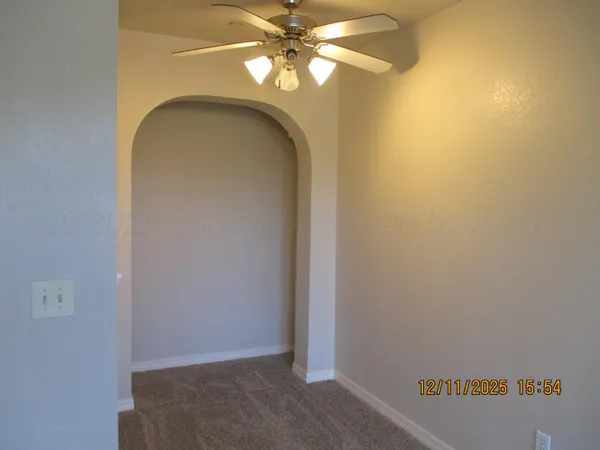 a view of a hallway with a chandelier fan