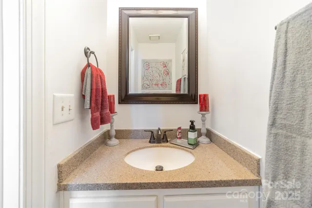 a bathroom with a granite countertop sink and a mirror