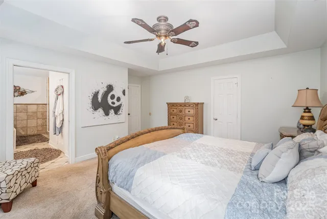 a bedroom with a large bed and a chandelier