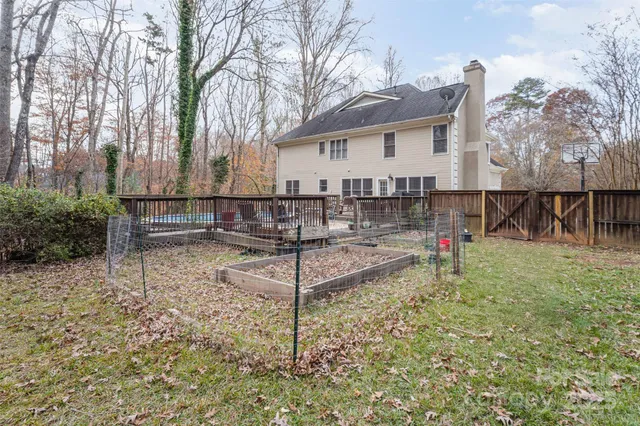 a view of house with backyard and a tree