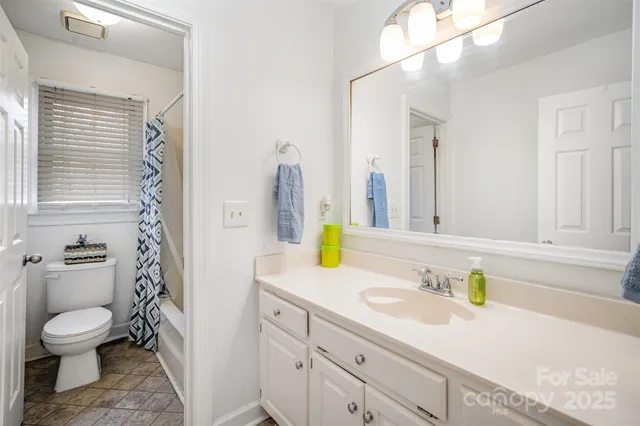 a bathroom with a granite countertop toilet sink and mirror