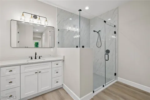 a bathroom with a double vanity sink mirror and shower