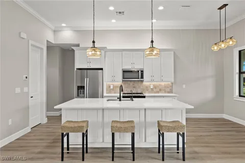 a kitchen with kitchen island white cabinets and refrigerator