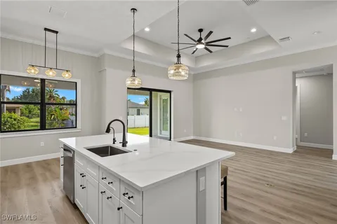 a kitchen with a sink a window and wooden floor
