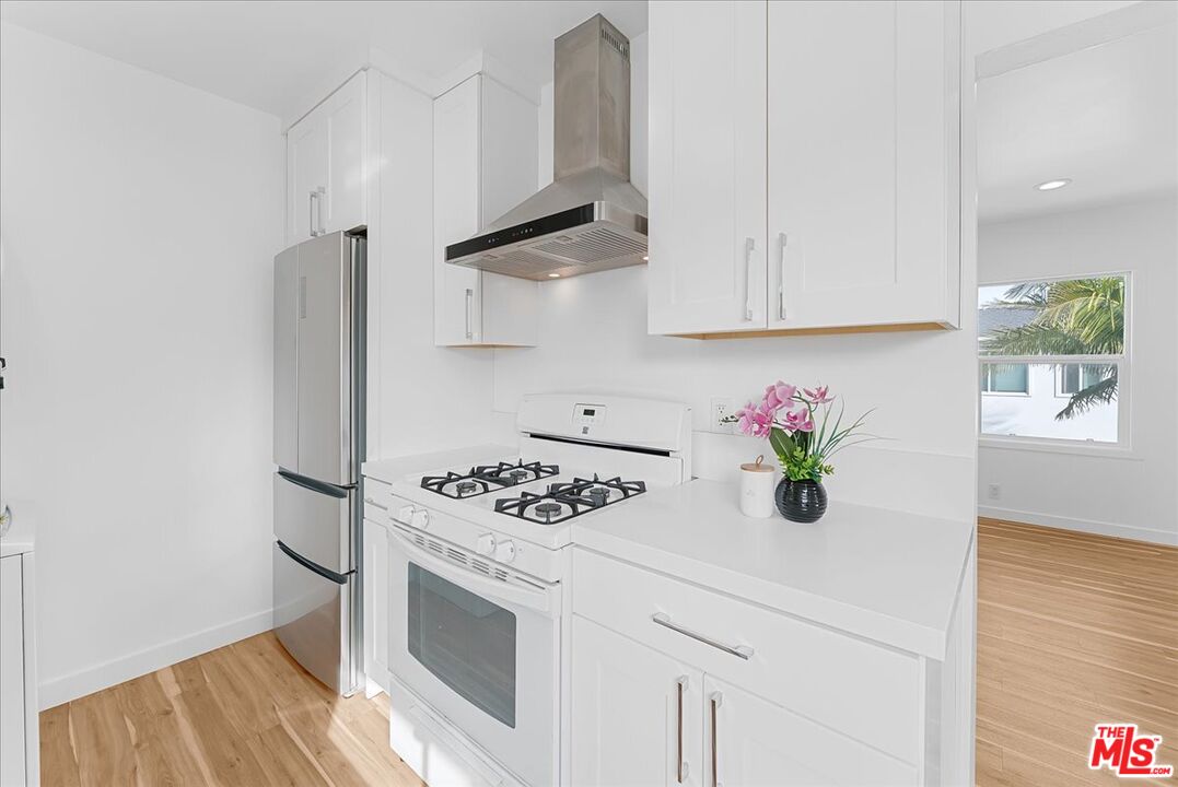 a kitchen with stainless steel appliances a white stove top oven and a white cabinets