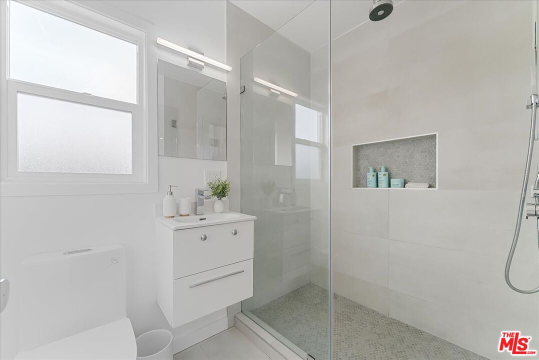 2948 Exposition Boulevard, Unit 7 Santa Monica, CA 90404 - Photo 11 of 15 a bathroom with a shower sink and mirror