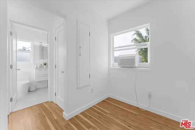 a view of a room with wooden floor and a bathroom